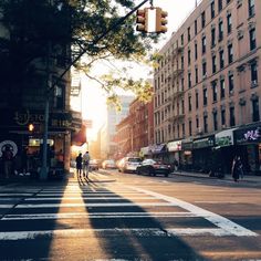 people crossing the street at an intersection on a sunny day