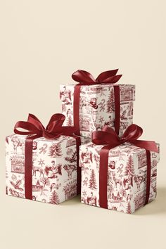 three presents wrapped in red and white christmas wrapping paper with bows on them, sitting next to each other