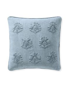 a blue pillow with embroidered flowers on it