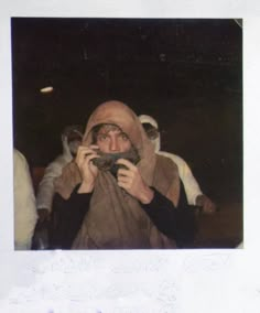 a person in a costume is taking a picture with a camera and some other people are behind him