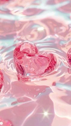 three pink hearts floating in the water