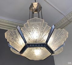 a chandelier hanging from the ceiling in a room with white walls and ceilings