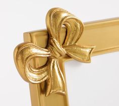 a gold bow is hanging on the side of a door