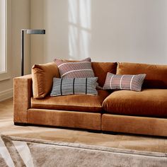 a brown couch with several pillows on it