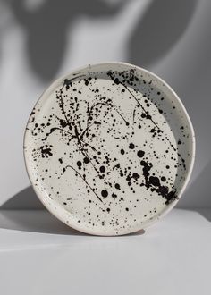 a white plate with black splatters on it