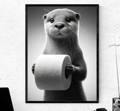 a black and white photo of an otter holding a roll of toilet paper