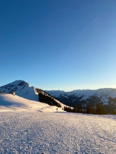 a person on skis in the snow with mountains in the backgrouund