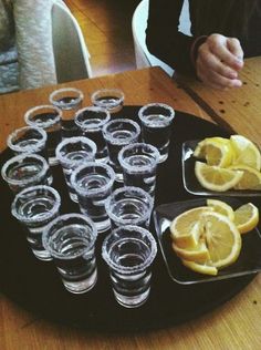 there are many glasses and lemons on the table