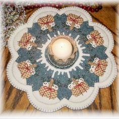 a lit candle sits in the center of a decorative plate with snowmen on it