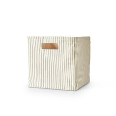 a white and brown striped storage bag with a wooden handle on the front, sitting against a white background