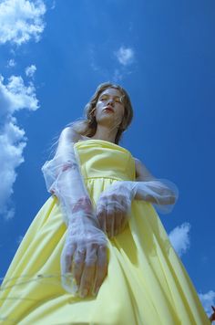 a woman in a yellow dress and white gloves