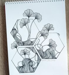 a drawing of flowers in a vase on top of a wooden table next to a spiral notebook