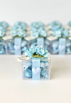 a small blue gift box with flowers in it sitting on a table next to other boxes