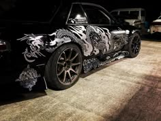 a black car with dragon designs on it's side