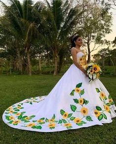 a woman in a wedding dress with sunflowers painted on the skirt and sleeves