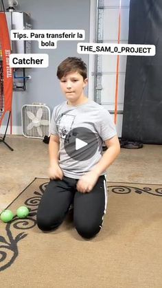 a young boy sitting on the floor with balls in front of him and another person standing behind him