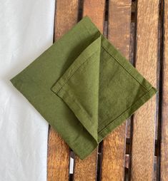 two folded napkins sitting on top of a wooden table