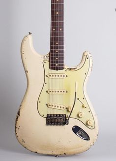 an old white guitar sitting on top of a table