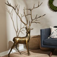 a golden deer statue next to a blue chair