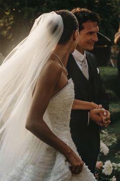 a bride and groom standing together in front of flowers