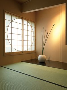 an empty room with a vase on the floor