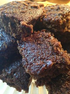 some brownies stacked on top of each other in a glass plate with one bite taken out