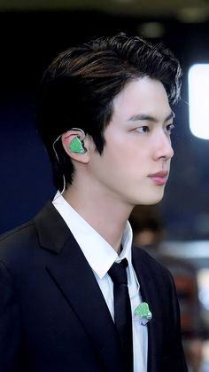 a man in a suit with ear buds on his ears