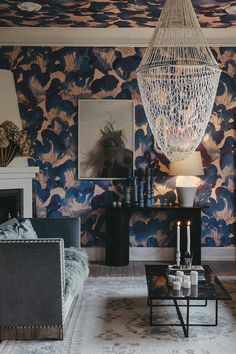 a living room filled with furniture and a chandelier hanging over the fire place