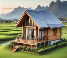 a small wooden house in the middle of a lush green field with mountains in the background