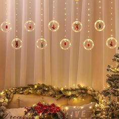 christmas decorations are hanging from the ceiling in front of a window with curtains and lights