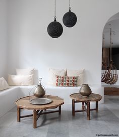 a living room with white walls and two round coffee tables on top of each other