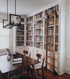 a dining room table with chairs and bookshelves