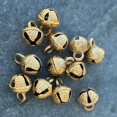 a bunch of gold bells sitting on top of a blue surface with one bell in the middle