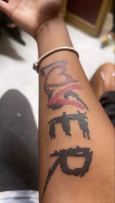 a woman's arm with some tattoos on it