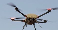 a close up of a flying object in the sky with red lights on it's wings