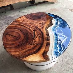 a table made out of wood and glass with the reflection of an ocean on it