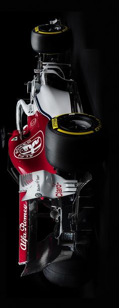 a red and white race car sitting in the dark