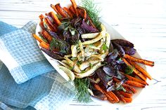 a white plate topped with carrots and other veggies next to a blue napkin