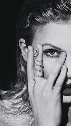 black and white photograph of a woman holding her hands to her face with rings on her fingers