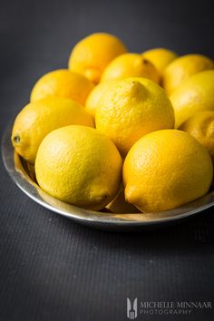 a bowl full of lemons sitting on a table