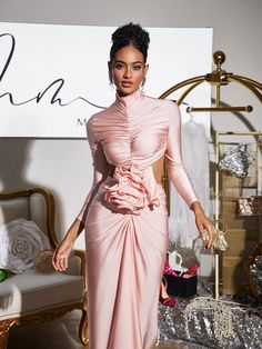 a woman in a pink dress walking down the runway