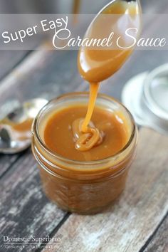 a spoon pouring caramel sauce into a jar on a wooden table with the words super easy caramel sauce