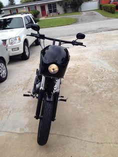 a black motorcycle parked in front of a white truck