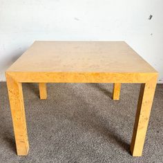 a wooden table sitting on top of a carpeted floor