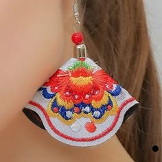 a close up of a person wearing some kind of earring with beads on it