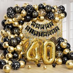 a happy birthday balloon arch with black and gold balloons in front of the number forty sign