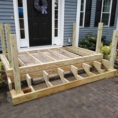 a wooden deck sitting in front of a house