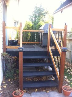 there is a set of stairs going up the side of a house with potted plants