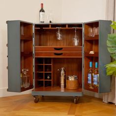 an open cabinet with bottles and glasses on it