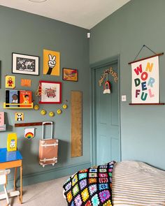 a bedroom with blue walls and pictures on the wall